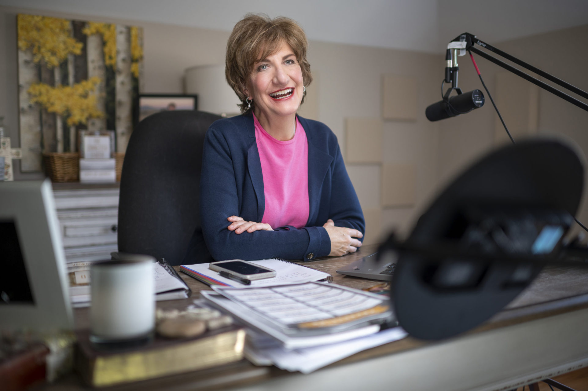 Karen Hardwick sitting at a desk with a microphone smiling