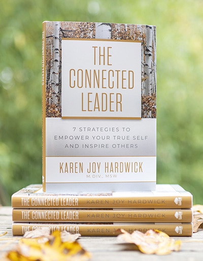 The Connected Leader book stacked on a porch with fall leaves